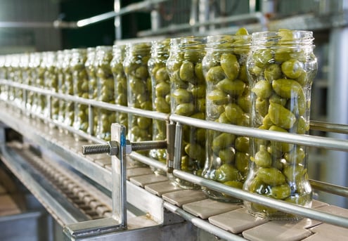 Olives in bottles in a factory 